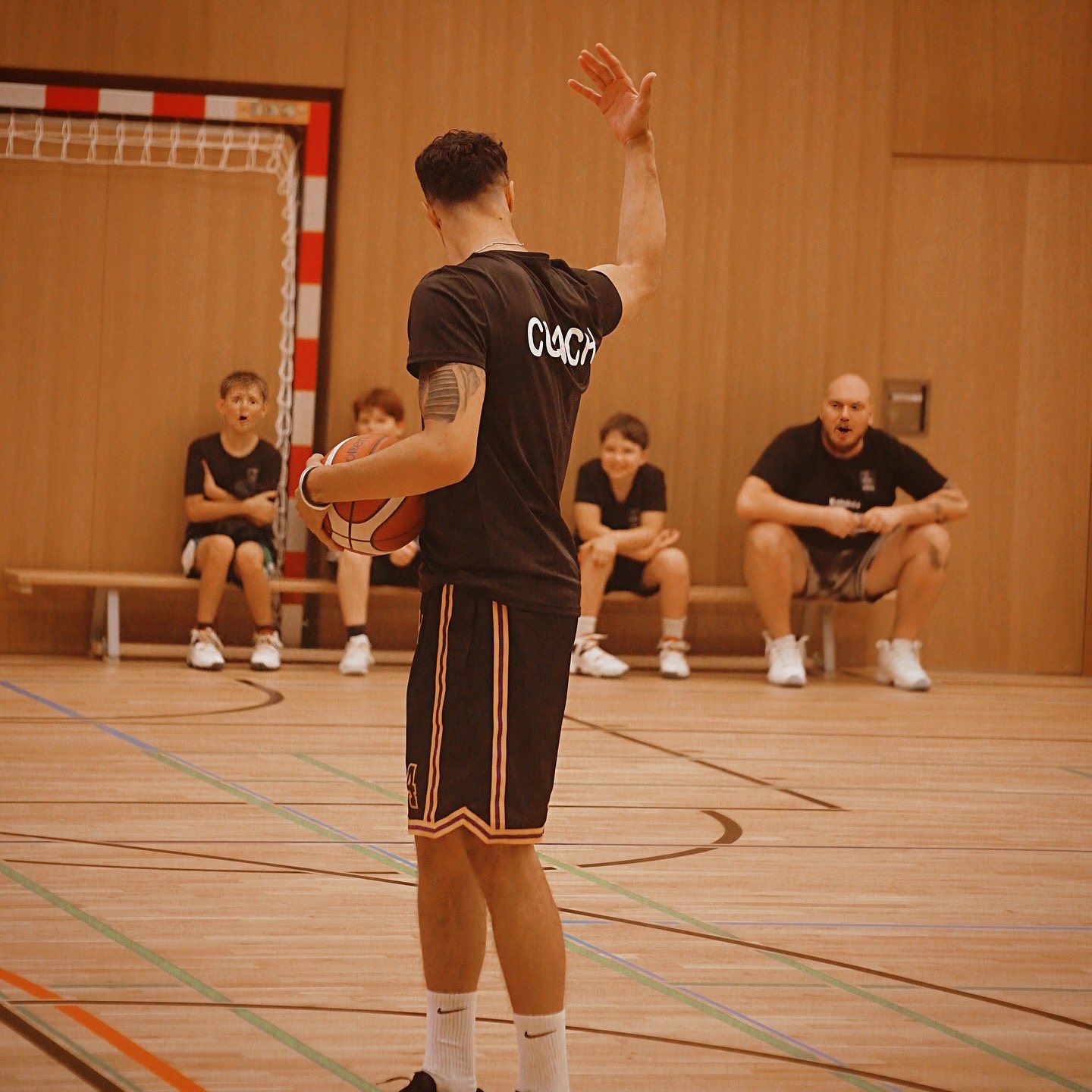 Coach explains a drill to kids in the gym